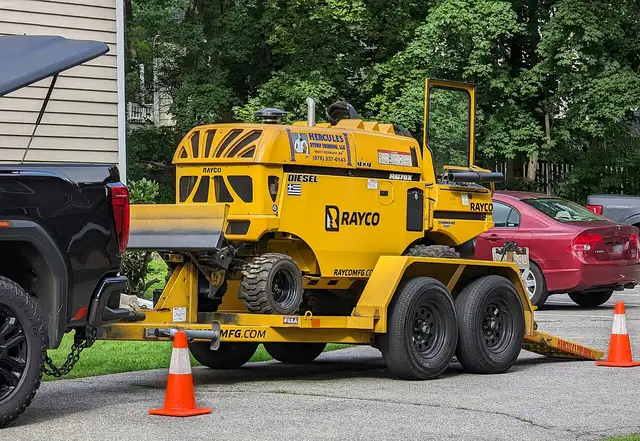 Tow-behind stump grinder parked by a curb